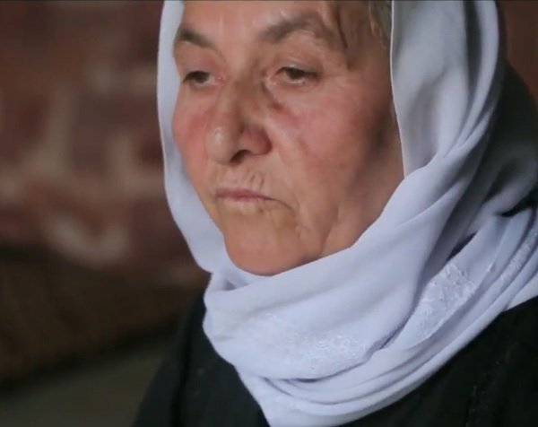 A Yazidi Old woman with pain in her eyes