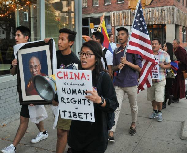 Kalsang Nangpa, front, who is the president of Students for a Free Tibet, at UMass, leads a group in a chant as they march on Main Street in Northampton, Wednesday, to protest the demolition of Tibetan Buddhist academy Larung Gar by the Chinese government.